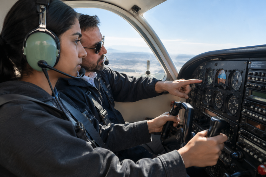 Instructor guiding a student pilot in a trainer aircraft cockpit